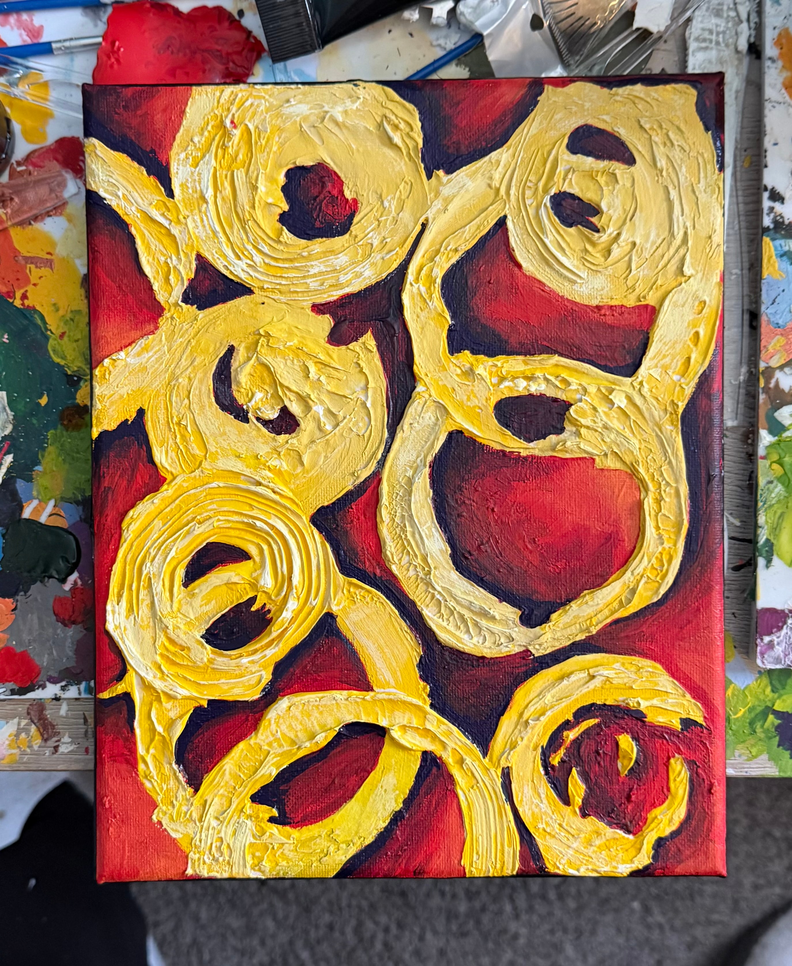 Golden Circles — original 8x10 abstract acrylic painting by Jay the Painter, Akron Ohio. Bold yellow and gold rings overlapping on deep crimson red background.