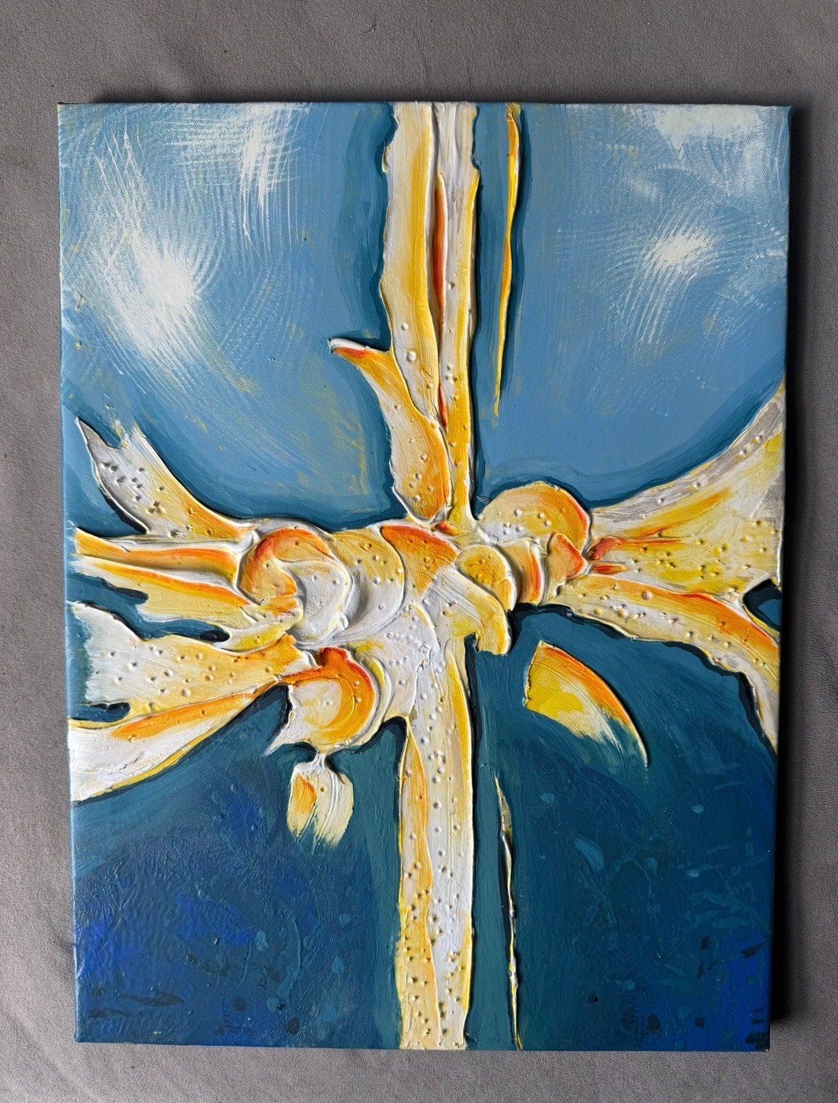 Nighttime Explosion — original 14x18 inch caulk art abstract painting by Jay the Painter, Akron Ohio. Explosive gold white and orange caulk rays bursting from center across deep blue to teal canvas, heavy 3D dimensional caulk texture technique, scattered caulk droplets radiating outward.