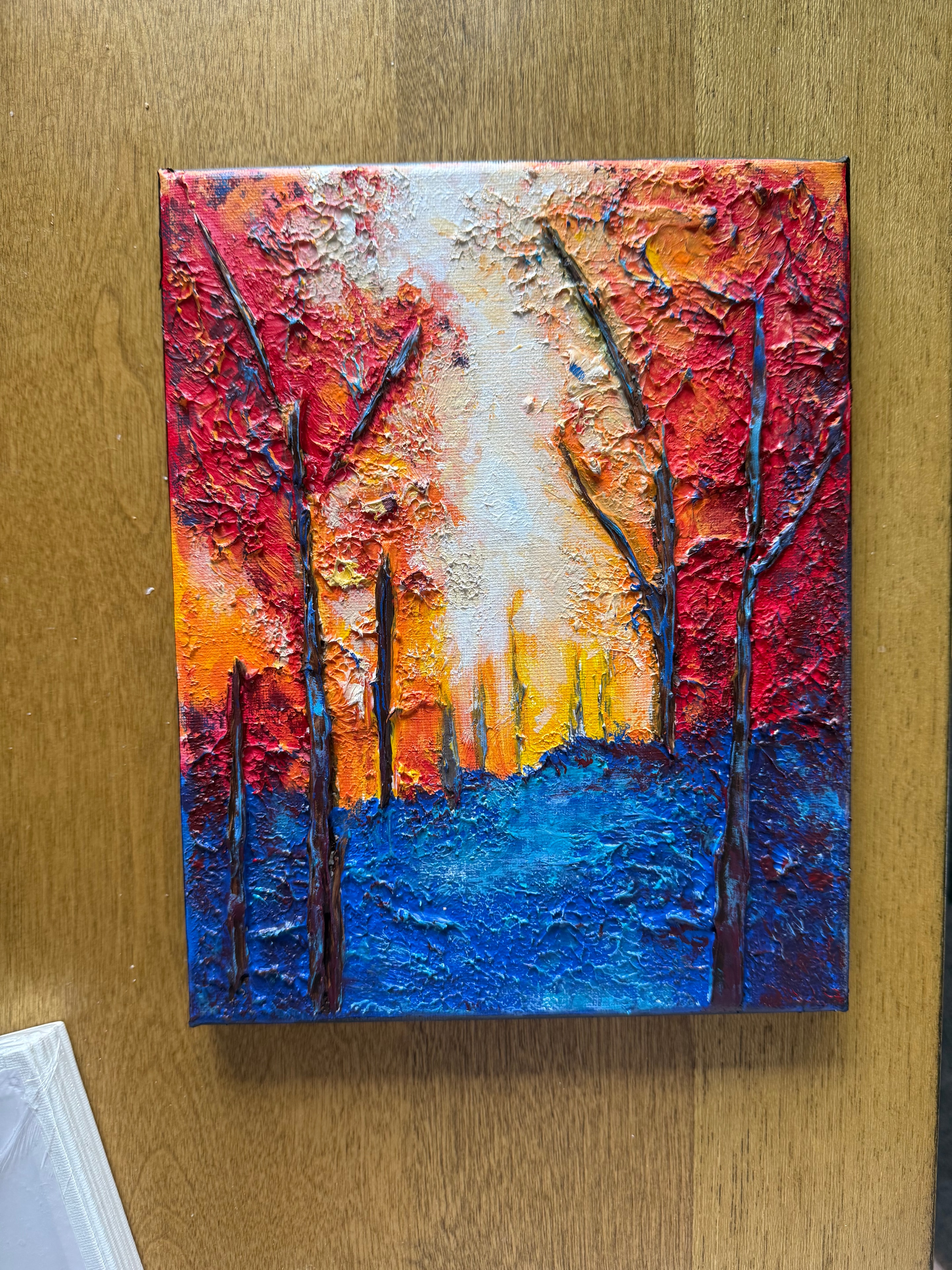 Ohio Autumn Fire and Blue Sky — original 8x10 inch caulk art landscape painting by Jay the Painter, Akron Ohio. Fiery red orange and golden yellow autumn tree canopy against bold cobalt blue sky, heavy 3D dimensional caulk texture technique, dark branch strokes throughout.