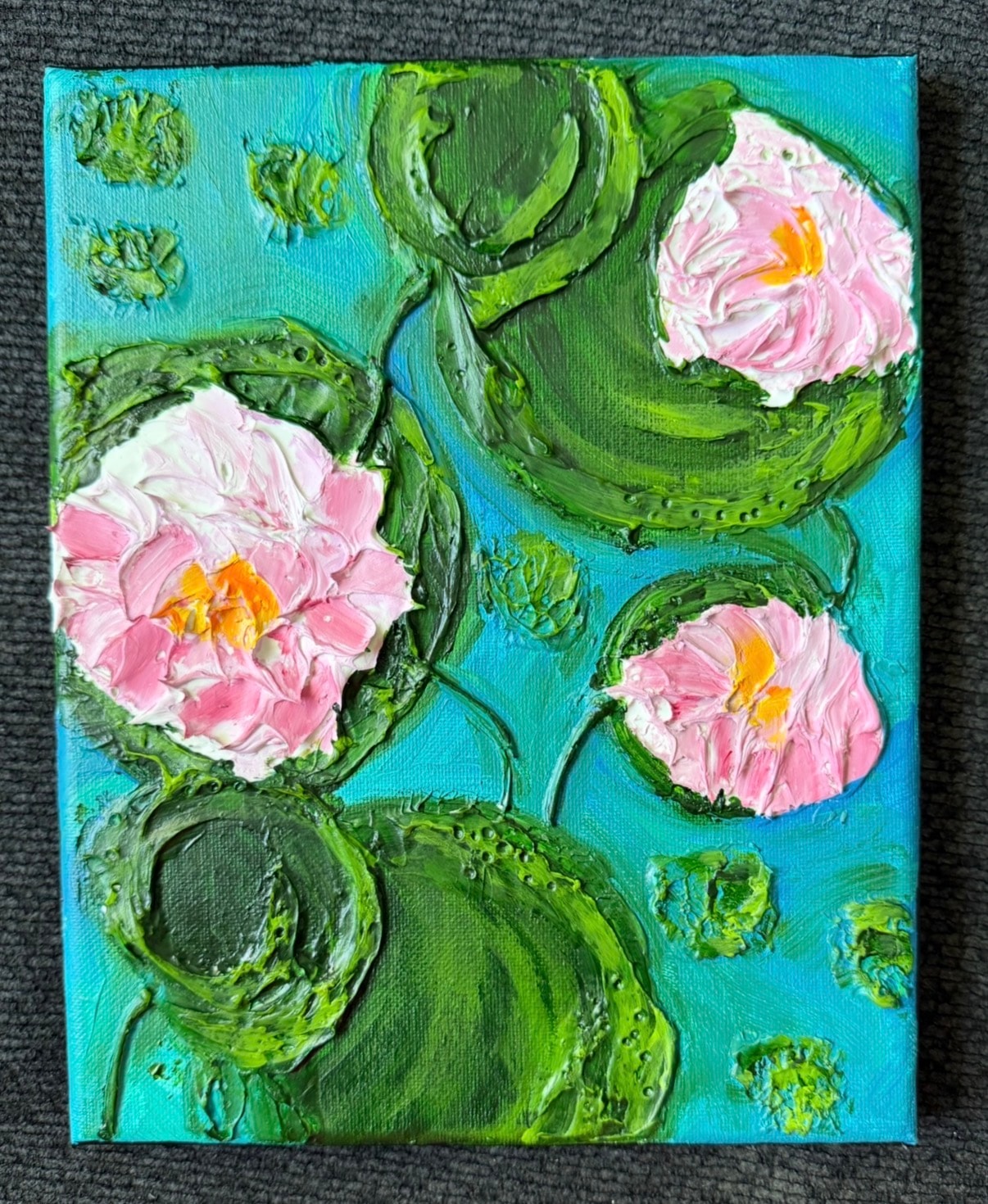 Water Lilies at Midday — original 8x10 inch caulk art painting by Jay the Painter, Akron Ohio. Three pink water lilies blooming across thick dimensional green lily pads on turquoise pond, heavy 3D caulk texture technique.